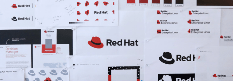 Pages of Red Hat stickers and logos hanging from a wall